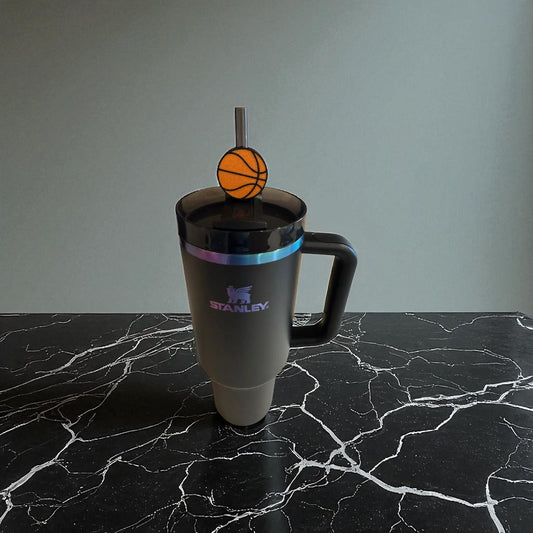 Tumbler with a basketball-themed straw on a marble surface