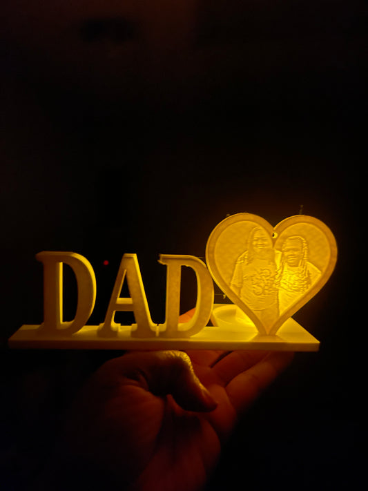 A 3D printed personalized DAD lithophane light display with a glowing heart, spelling out the word 'DAD' in capital letters.