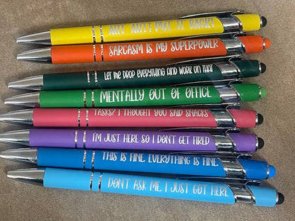 Stack of pens with humorous text on a brown surface