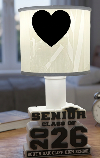 Lamp with photos and Senior Class of 2026' text on a wooden table.