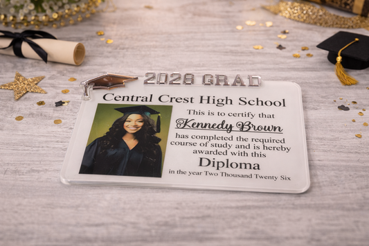 Graduation diploma party favor with a photo of a graduate and confetti on a wooden surface.