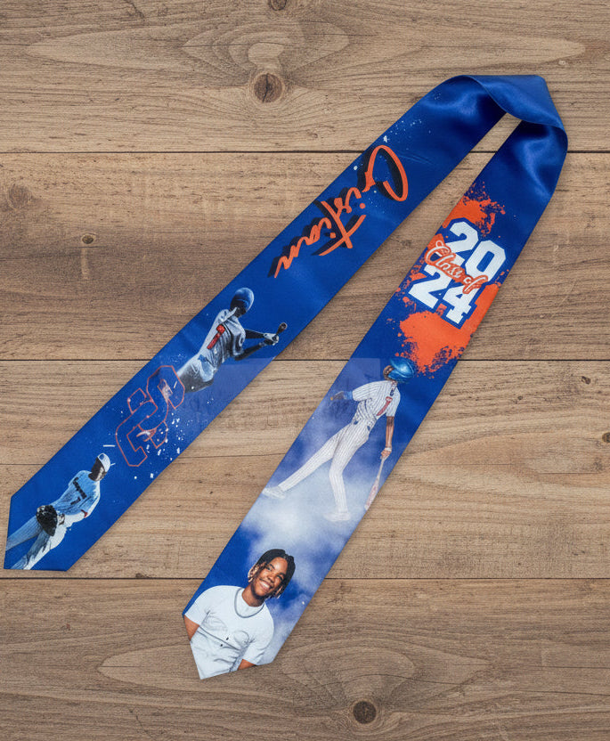Blue grad stole with sports-themed design on a wooden surface