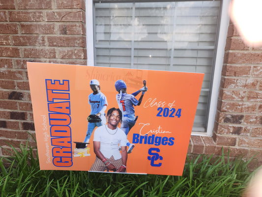 An orange yard sign with a photo of a graduate in a white shirt, featuring the text 'GRADUATE' and 'Class of 2024', along with the name 'Bridges' and the school logo 'SC'.
