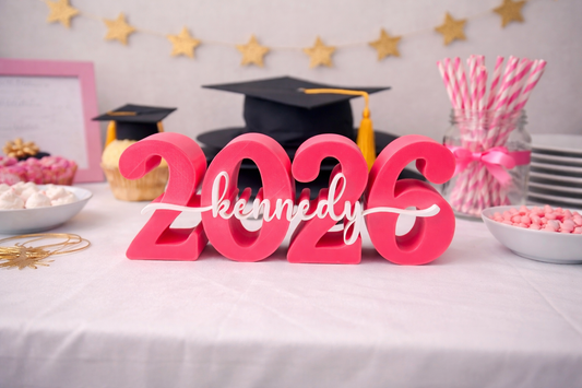 Graduation-themed table setup with '2026' and 'kennedy' decorations.