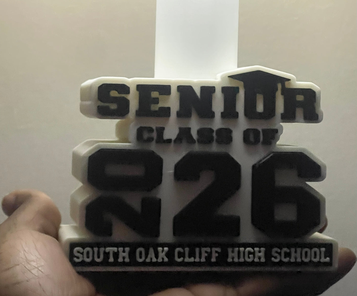 3D-printed lamp base with Senior Class of 2026' text held by a hand against a white background