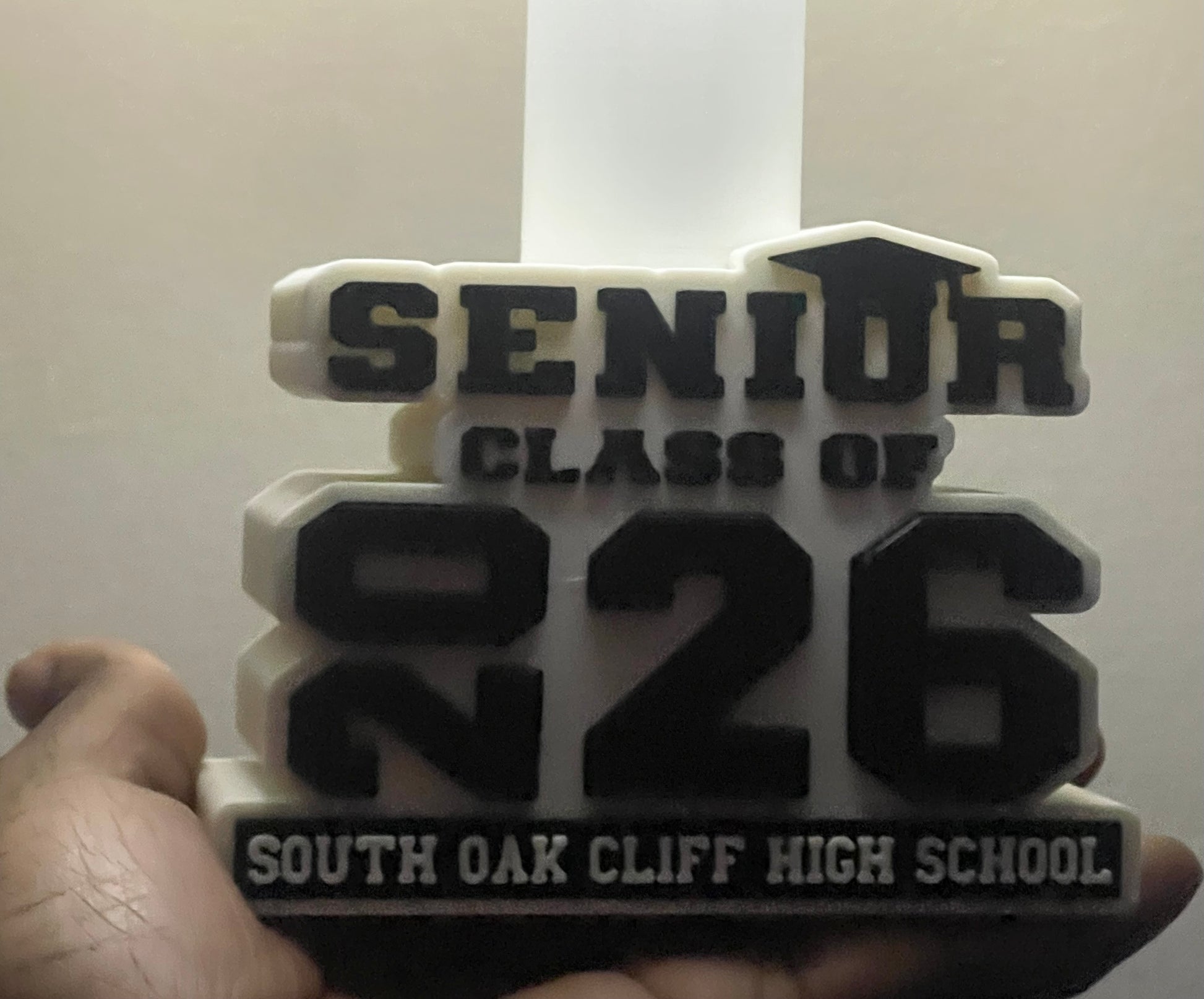 3D-printed lamp base with Senior Class of 2026' text held by a hand against a white background