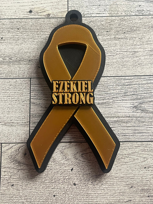 Gold and black cancer ribbon backpack with text on a wooden surface